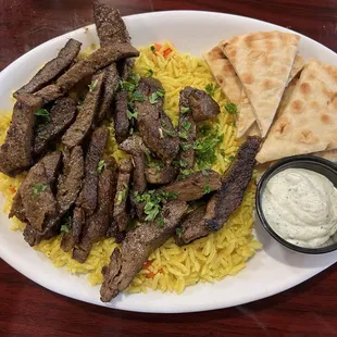 Beef and lamb Gyro on a plate with rice, pita bread