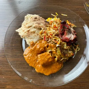 My take out! a piece of naan, butter masala with paneer, goat biryani, and tandoori chicken.