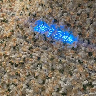  a neon sign in a bed of flowers