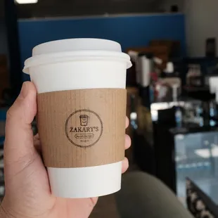 a hand holding a coffee cup