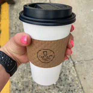 a hand holding a coffee cup