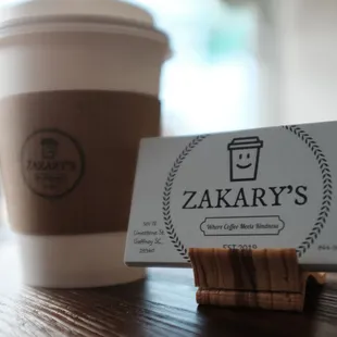a cup of coffee and a business card