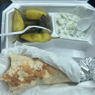 Chicken shawarma sandwich, pepperchini, grape leaves, cucumber yogurt salad.