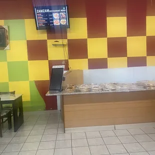 Menu above counter of breads ..in restaurant area.