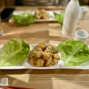 a plate of food with lettuce and chopsticks