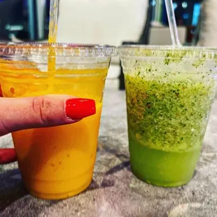 a woman's hand holding a plastic cup of juice