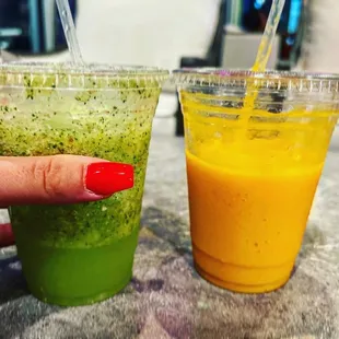a woman's hand holding a plastic cup of juice