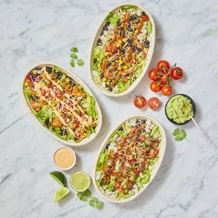 three plates of mexican food on a marble table