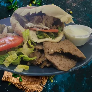 Gyro Pita. Lamb and beef slow roasted, thinly sliced. Stuffed into homemade pita w/ lettuce, tomato, onion, pickle, and zesty tzatziki sauce
