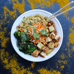 a bowl of food with chopsticks