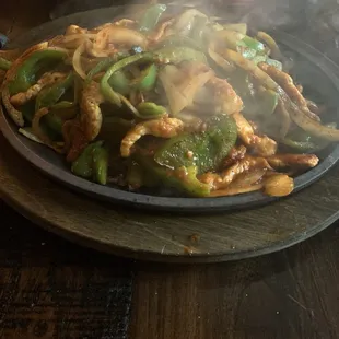 Sizzling Chicken Fajitas,with peppers and onions , refried beans and rice on the side