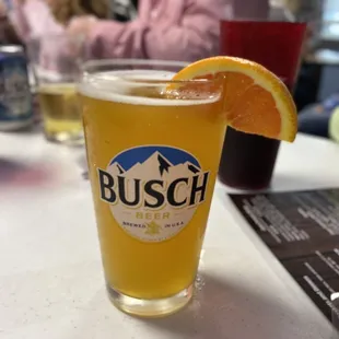 a glass of beer with a slice of orange