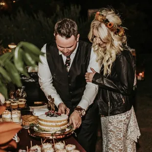 a bride and groom cutting their wedding cake