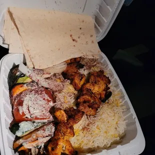 a takeout container with a variety of food items