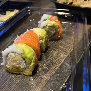 a sushi roll with salmon and avocado