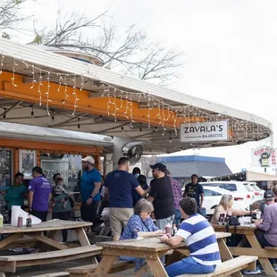 people sitting at picnic tables