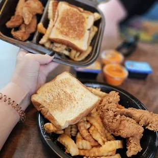 two plates of fried chicken and fries