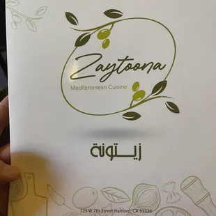 a person holding a box of olive oil
