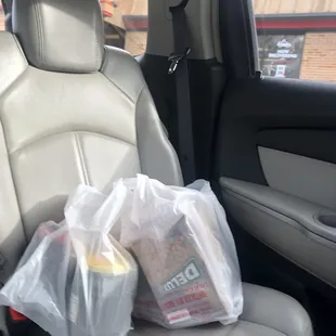 two bags of food in the back seat of a car
