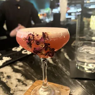 a pink cocktail with dried flowers in it