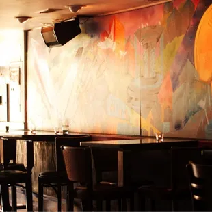 a restaurant with a large mural on the wall