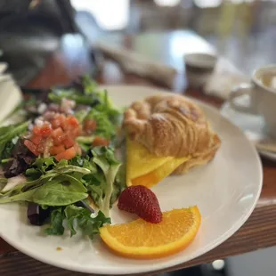 Croissant with omelette, salad and fruit