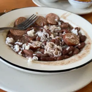 a bowl of beans and rice with a fork