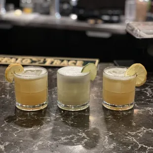three cocktails on a bar