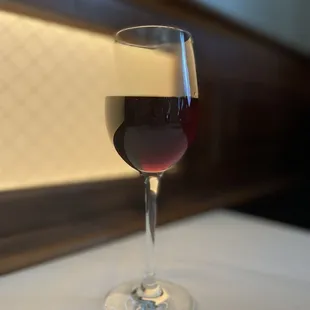 a glass of red wine on a table