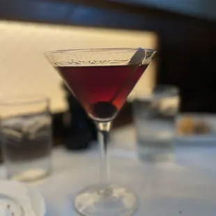 a glass of wine sitting on a table