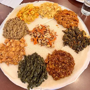 From top: yedoro alica, yetakelt wat, gomen wat, tilapia, spinach, spicy chicken, yesimir wat, and gomen alicha. Cauliflower in the middle.
