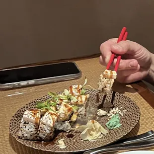 a person eating sushi with chopsticks