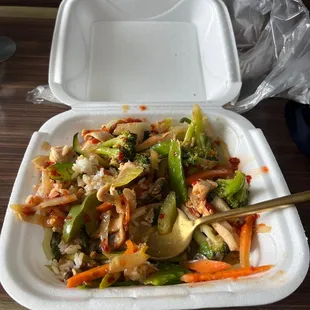 a takeout container with a salad in it