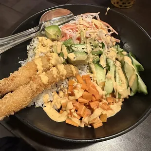 Poke bowl with sushi rice, shrimp tempura, crab, cucumber, carrot, avocado and spicy mayo