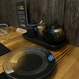 a table setting with teapots and plates