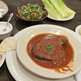 a bowl of tomato soup and a plate of salad