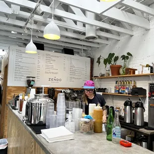 a man behind the counter of a coffee shop