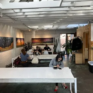 a woman sitting at a white table in a large open space