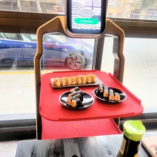 a tray of sushi and a tray of rolls