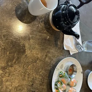 a plate of food and a teapot on a table