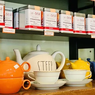 a shelf of tea bags and teapots