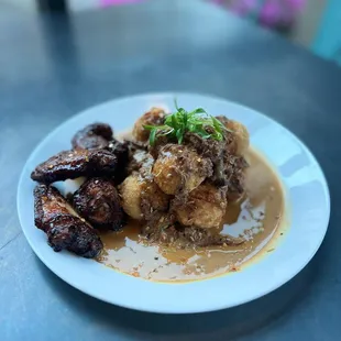Deep fried Grits and Oxtail gravy with jerk chicken