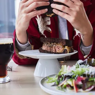  woman eating a sandwich and a salad