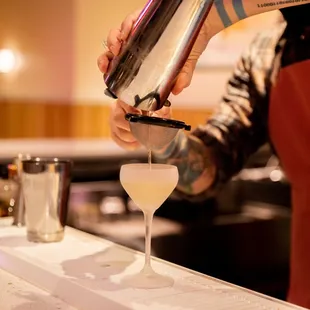  bartender pouring a cocktail