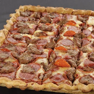 a square pizza with pepperoni and sausage