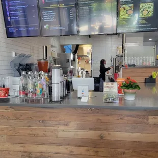 a restaurant counter with menus on the wall