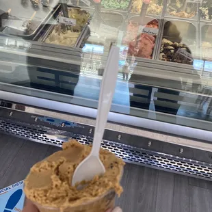 a hand holding a scoop of ice cream