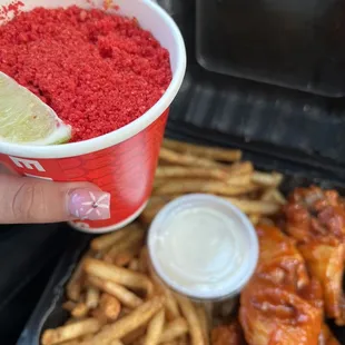 a person holding a cup of food