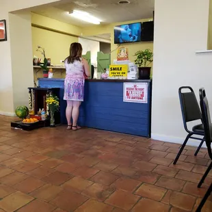 a woman standing at a counter in a restaurant