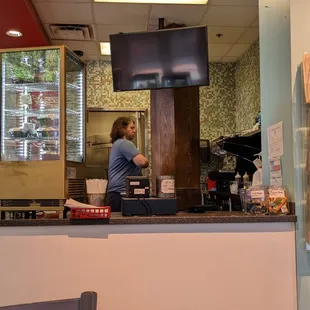 a man standing at a counter in a restaurant